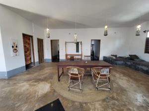 a living room with a wooden table and two chairs at Hiliki private house in Umbuji