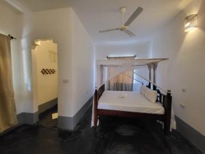 a room with a bed with a ceiling fan at Hiliki private house in Umbuji +23 photos
