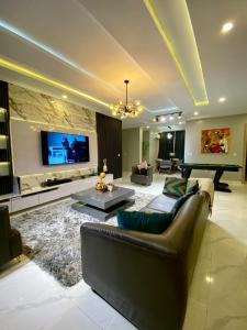 a large living room with a couch and a tv at Sabolak Suite-Oak 2 Bedroom in Lagos