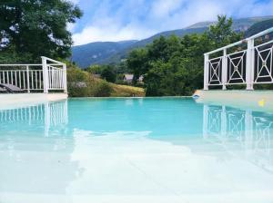 Sainte EngraceにあるGîte Ainerak - Spa & Piscine au Pays Basqueの青い水と山々を背景にしたスイミングプール