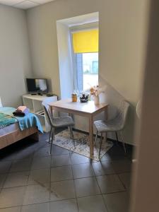 a room with a table and chairs and a bed at Šiauliu apartamentai in Šiauliai