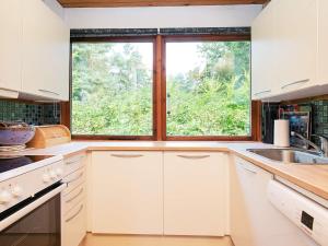 eine Küche mit weißen Schränken und einem großen Fenster in der Unterkunft 4 person holiday home in Gedser in Gedser + 8 Fotos