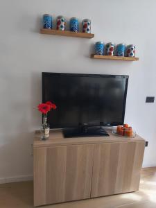 a flat screen tv sitting on top of a wooden entertainment center at Girasole Casa Vacanza in Stradella