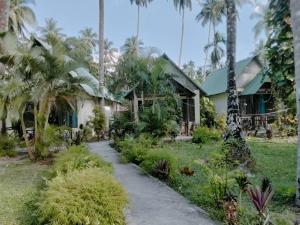 una casa con palmeras y un camino en Ocean Pearl Beach Resort, en Isla Havelock
