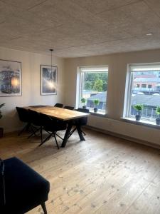a dining room with a table and two windows at 3 værelses lejlighed in Herning