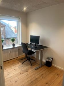 an office with a desk with a computer on it at 3 værelses lejlighed in Herning