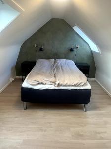 a bedroom with a bed with two lights on the wall at 3 værelses lejlighed in Herning