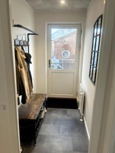 a hallway with a door and a bench and a window at 3 værelses lejlighed in Herning
