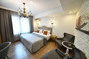 a hotel room with a bed and two chairs at The Marions Suite - Central Comfortable Stay in Taksim in Istanbul