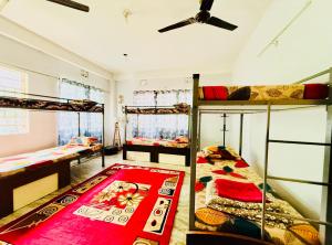 a room with three bunk beds and a ceiling fan at Backpackers Bunkhouse Siliguri 8Bed WHY WAIT in Siliguri