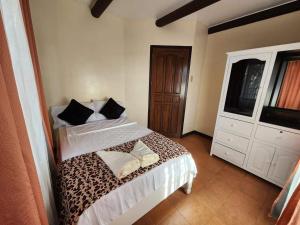 ein Schlafzimmer mit einem Bett mit zwei Kissen darauf in der Unterkunft The Wood Cabin Home Tagaytay with Billiards and Minipool 10mins from Skyranch in Galicias