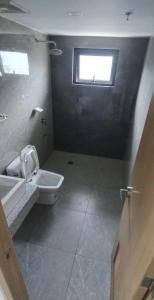 Sampongにある1 Bedroom Quirino Ave Paranaqueのトイレ、洗面台、窓のあるバスルーム