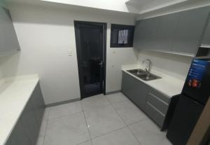 Sampongにある1 Bedroom Quirino Ave Paranaqueの小さなキッチン(シンク、黒いドア付)