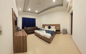 una camera da letto con un letto e un divano di The Maple Stays a Gurgaon