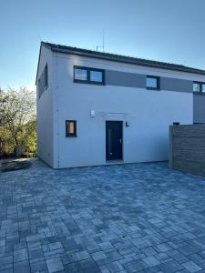 a large white building with a door and a driveway at Holiday Home Prague Šeberov in Prague