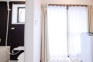 a bathroom with a shower curtain and a toilet at Rakuyodo Higahikujo in Kyoto +58 photos
