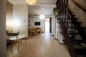 a living room with a staircase and a dining room at Rakuyodo Higahikujo in Kyoto