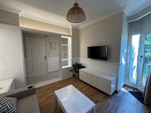 a living room with a couch and a tv at Apartment with nice garden in Sheikh Zayed