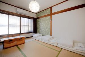 a room with two beds and a large window at Rakuyodo Higahikujo in Kyoto