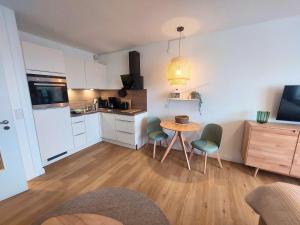 a kitchen with a table and chairs in a room at Apartment Hygge mit Ostseeblick in Wendtorf