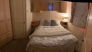 a small bedroom with a bed with white sheets and pillows at 167 Ashburton in Longridge