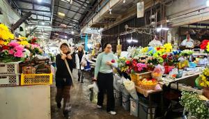 a group of people walking through a market with flowers at Napahong Treehouse forest camp in Ban Pa Ha