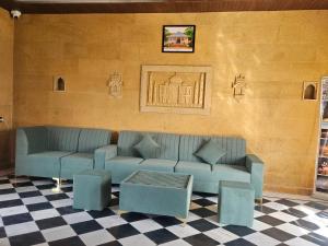 a living room with a blue couch and a table at Kharai desert luxury camp in Jaisalmer
