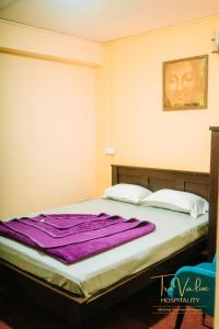 a bed in a room with a purple blanket on it at Shenga Palace by truvalue hospitality in Jāmb