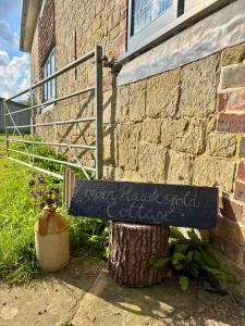 ein Schild an der Seite eines Backsteingebäudes in der Unterkunft Cottage Within Country Estate in Fernhurst