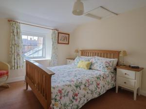 a bedroom with a bed and a window at Vine Cottage in Burton Bradstock