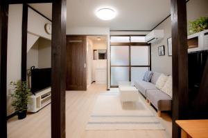 a living room with a couch and a tv at GUAGUA house in Kyoto