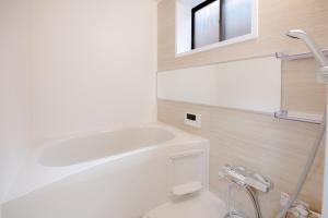 a bathroom with a white toilet and a bath tub at GUAGUA house in Kyoto