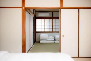 a bedroom with two beds and sliding glass doors at GUAGUA house in Kyoto