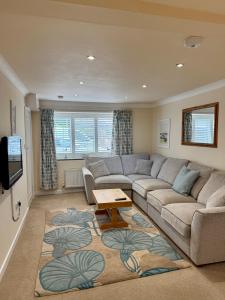 ein Wohnzimmer mit Sofa und Tisch in der Unterkunft Pirans Apartments in Perranporth