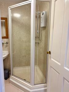 eine Dusche mit Glastür im Badezimmer in der Unterkunft Pirans Apartments in Perranporth