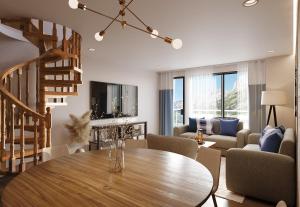 a living room with a wooden table and a spiral staircase at Tarbey Alpine Apartment Leukerbad in Leukerbad
