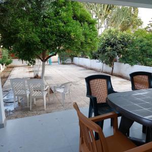 a patio with a table and chairs and a tree at ALEX FRUIT TREE HOME in Voroklini