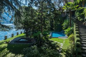 a yard with a swimming pool next to a house at Luxury Villa at Como Lake in Carate Urio