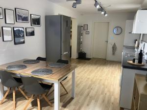 a kitchen with a table and chairs and a refrigerator at Schöne FeWo im Illertal in Oberopfingen +3 photos