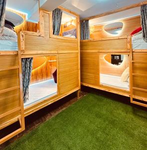 a bedroom with two bunk beds with green carpet at Yog Hostel- Rooftop Yoga & Backpacker Social Stay in Thamel, Kathamndu in Kathmandu +258 photos