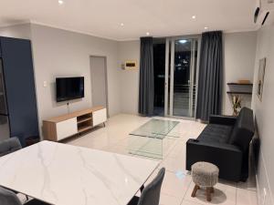 a living room with a black couch and a television at 10 Bond Square in Durban