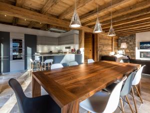 une cuisine ouverte et une salle à manger avec une table et des chaises en bois dans l'établissement Chalet luxueux 4****, calme, proche pistes ski, 10 pers, WiFi, parking - FR-1-304-196, à La Clusaz