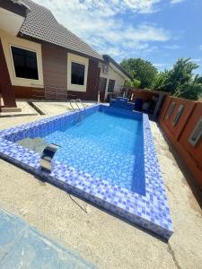 a blue tile swimming pool in front of a house at IMAN Homestay in Melaka