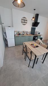 a kitchen with a wooden table and chairs in a room at La baraque bleriot beach in Sangatte