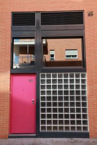 a red and pink door in a brick building at Alojamiento ciudad las artes in Valencia