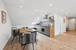 a kitchen and dining room with a table and chairs at Yello Homes - 4 Gäste - 2 Zimmer - Großartiger Blick in Herzogenaurach