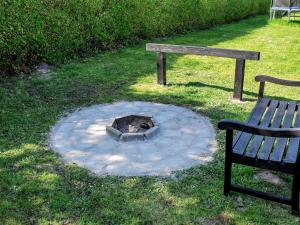 a fire pit sitting next to a park bench and a fire pit at Luxury Pool House by Sea - By Traum Ferienwohnungen in Nordborg