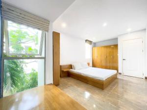 Nhơn TrạchにあるLumiere Villa Swanbayのベッドと大きな窓のある寝室