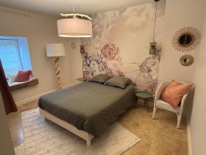 a bedroom with a large bed and a chair at Au Pressoir de Boisy in Pouilly-les-Nonains