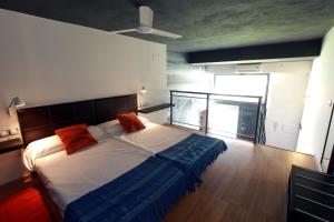 a bedroom with a bed with orange pillows on it at Alojamiento ciudad las artes in Valencia